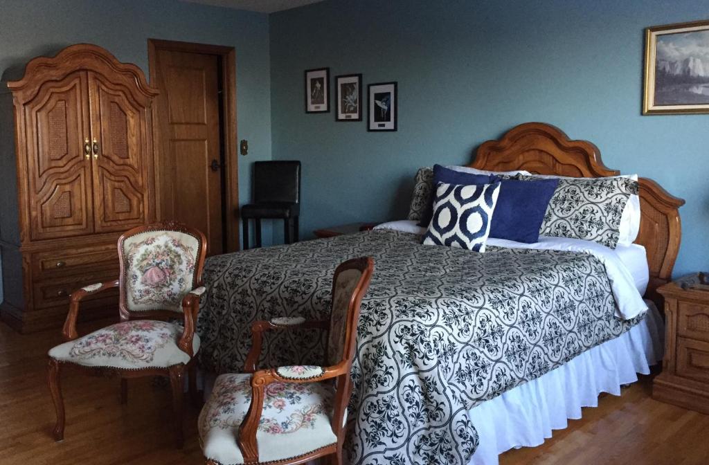 a bedroom with a bed and two chairs at Paola Beauty Farm B&B and Day Spa in Dalroy