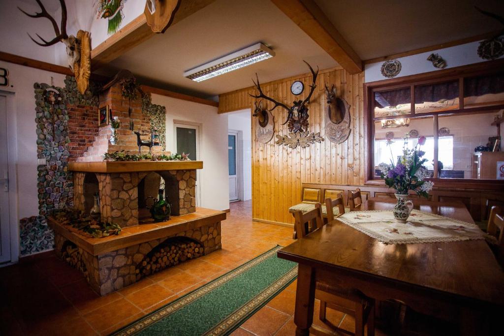 ein Wohnzimmer mit einem Kamin, einem Tisch und Stühlen in der Unterkunft Casa Cerbului1 in Sebeş