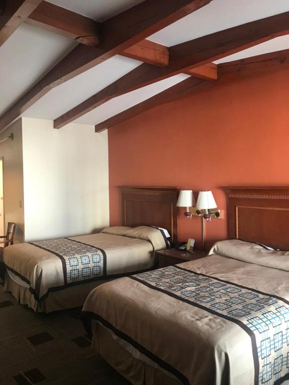 2 camas en una habitación de hotel con paredes rojas en Wayfarer Motel, en Myrtle Beach