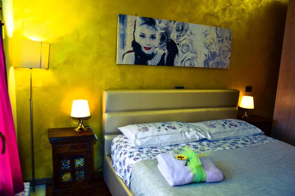 a bedroom with a bed with two lamps and a painting at Villa Anis Bed and Breakfast in Selvazzano Dentro