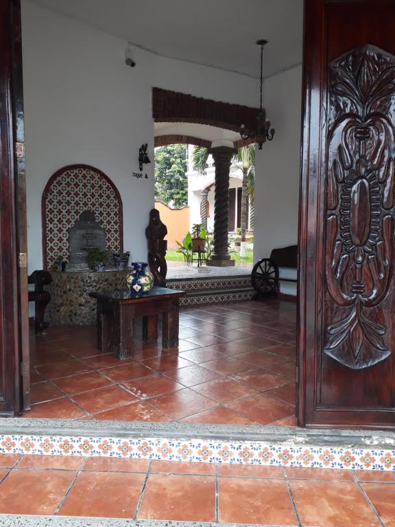 een woonkamer met een grote houten deur bij Hotel Villa Palmeras in Tecolutla