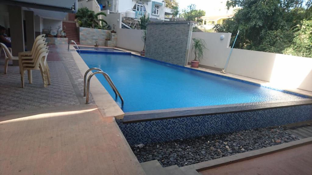 a swimming pool on the side of a house at Luxor appartement in Flic-en-Flac