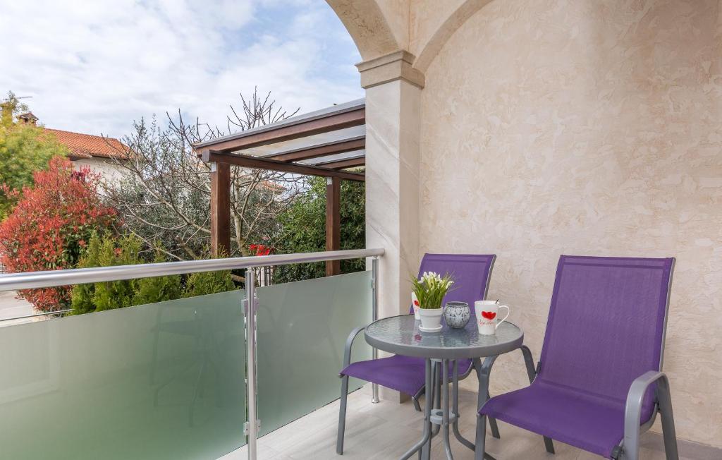 a patio with purple chairs and a table on a balcony at Villa Stephany in Poreč