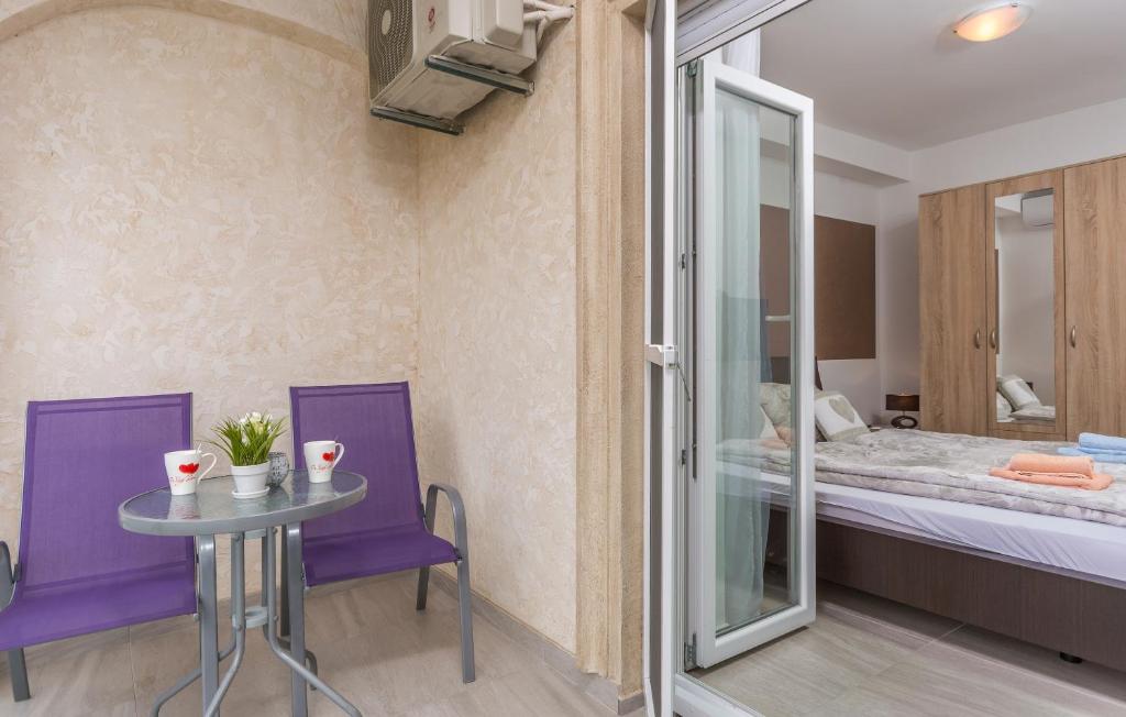 a room with a table and purple chairs and a bed at Villa Stephany in Poreč