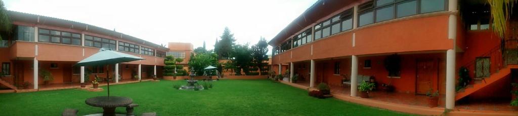 un patio de un edificio con césped verde en Hotel Ollin Teotl en San Juan Teotihuacan