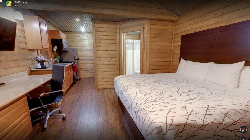 a small bedroom with a bed and a kitchen at Paradise RV & Cabins Resort in Vinton