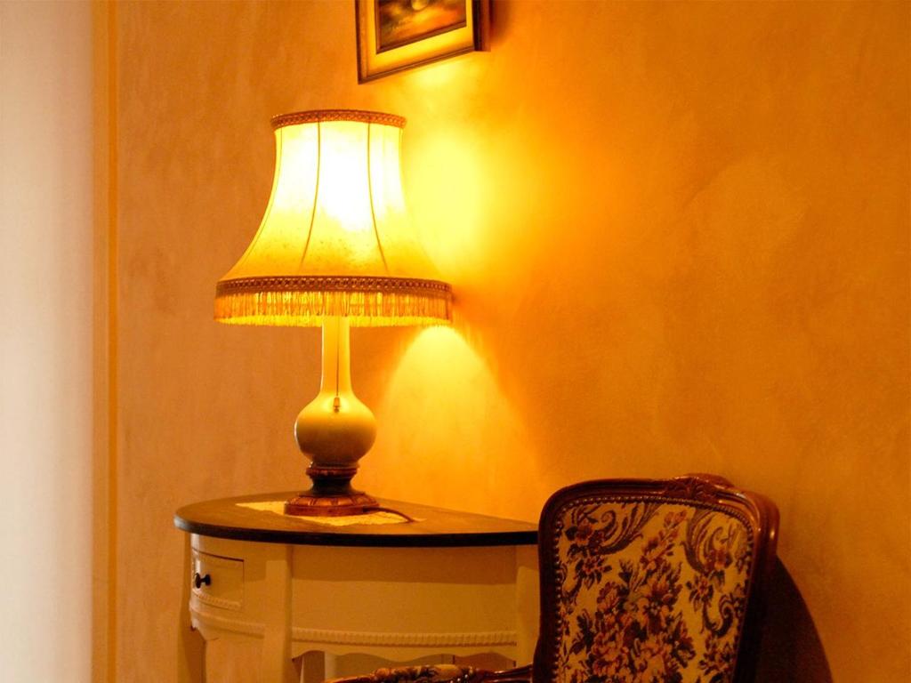 a lamp sitting on a table next to a chair at NM-APARTMENTS in Griesheim