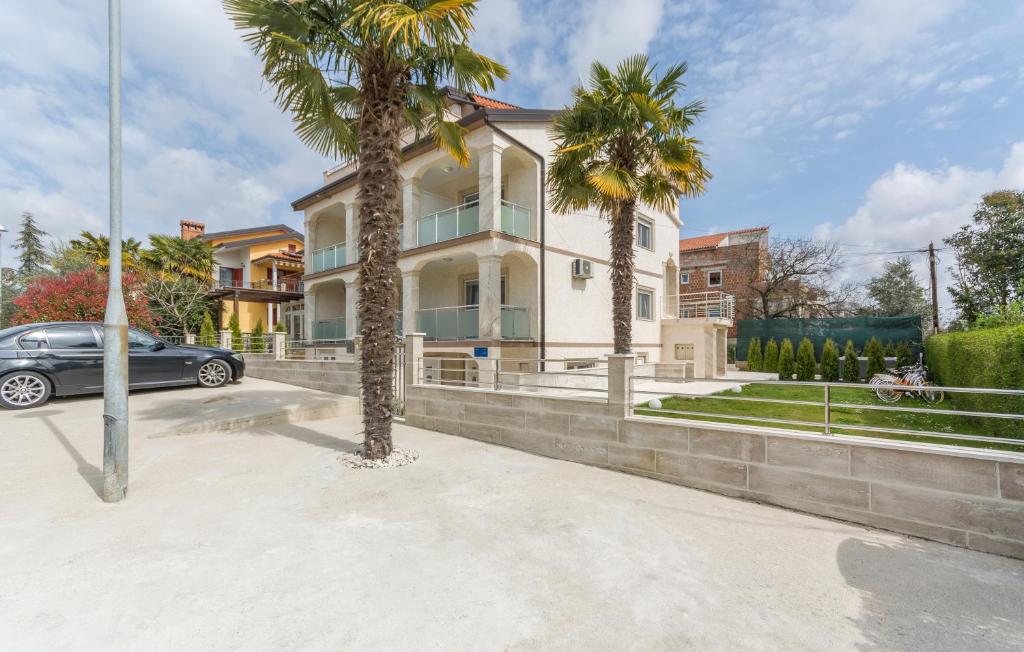 a car parked in front of a house with palm trees at Villa Stephany in Poreč