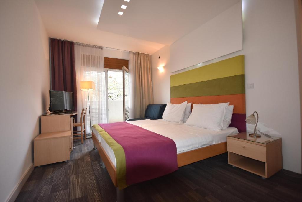 a hotel room with a bed and a tv at Hotel Hecco in Sarajevo