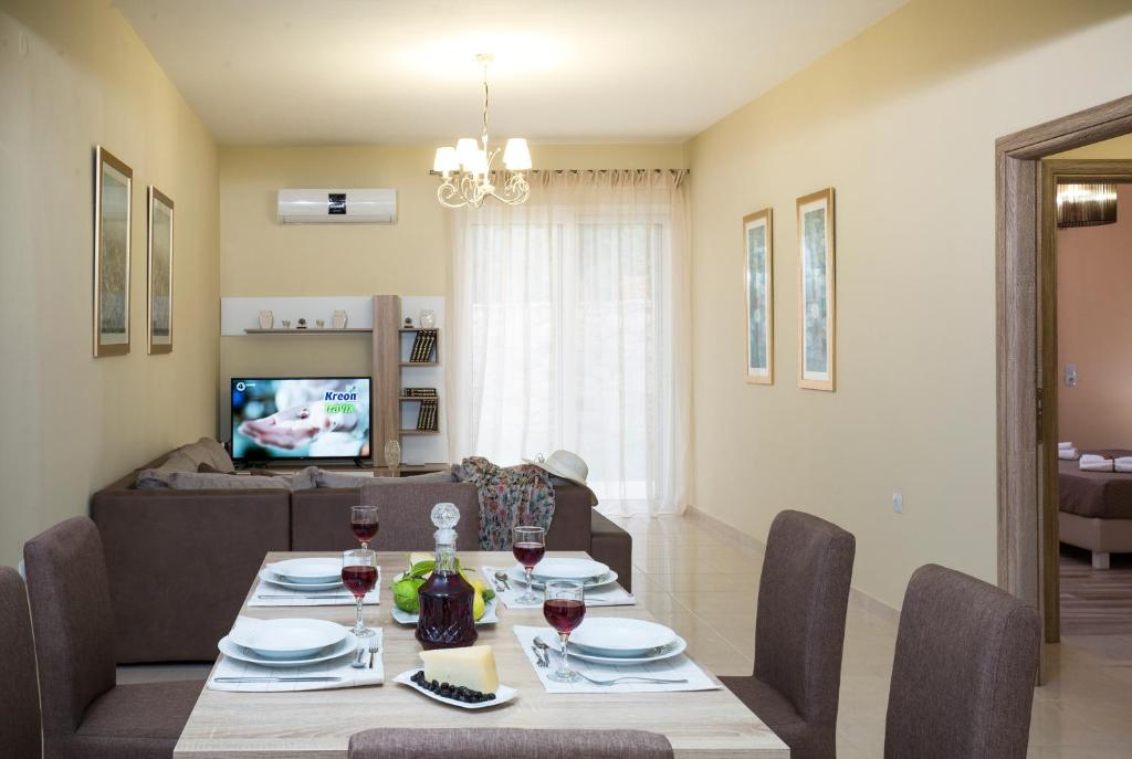 a dining room and living room with a table and chairs at Georgia Sunset in Trákhilos