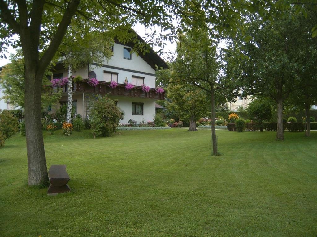 una gran casa blanca con un patio con árboles en Ferienwohnungen Marktl, en Sankt Kanzian