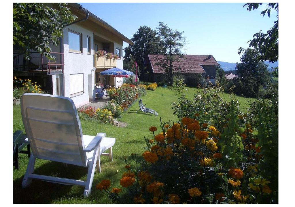 uma cadeira branca sentada no quintal de uma casa em All inkl Card Fewo1-Heigl em Viechtach