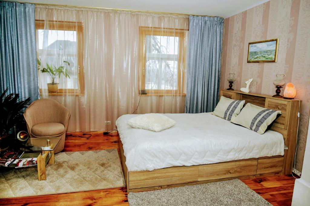 1 dormitorio con 1 cama, 1 silla y 1 ventana en Līvijas apartamenti, en Kuldīga