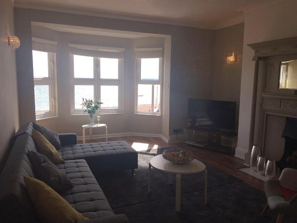 a living room with a couch and a table at Stones Throw From The Beach - Stunning Sea View in Portsmouth