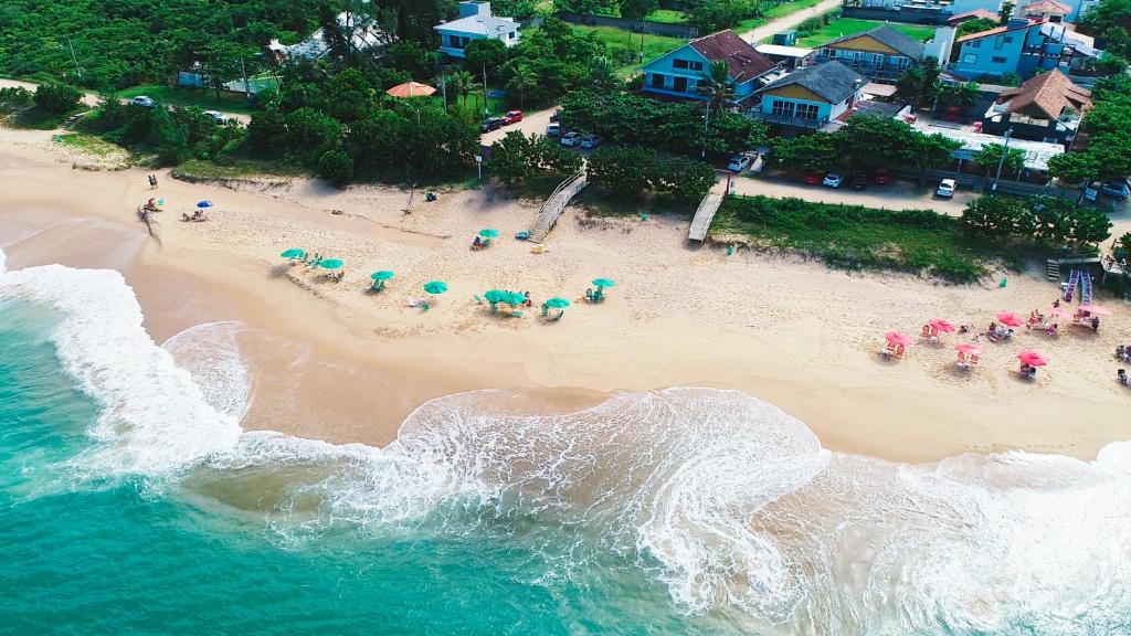 z góry widok na plażę z ludźmi i parasolami w obiekcie Pousada OceAnas Frente Mar Estaleiro w mieście Balneário Camboriú