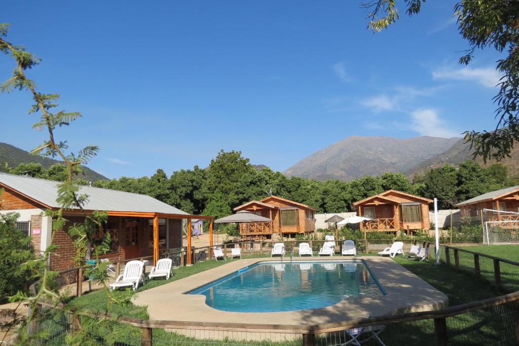 un resort con piscina e montagne sullo sfondo di Cabañas Antilhue a Olmué
