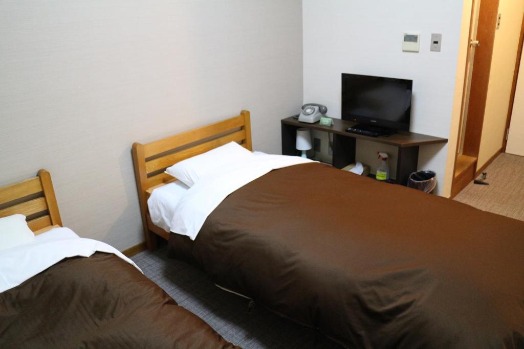 Postel nebo postele na pokoji v ubytování Hotel New Kotobuki