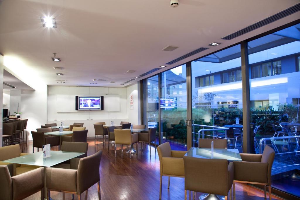 a restaurant with tables and chairs and windows at Divan Istanbul City in Istanbul