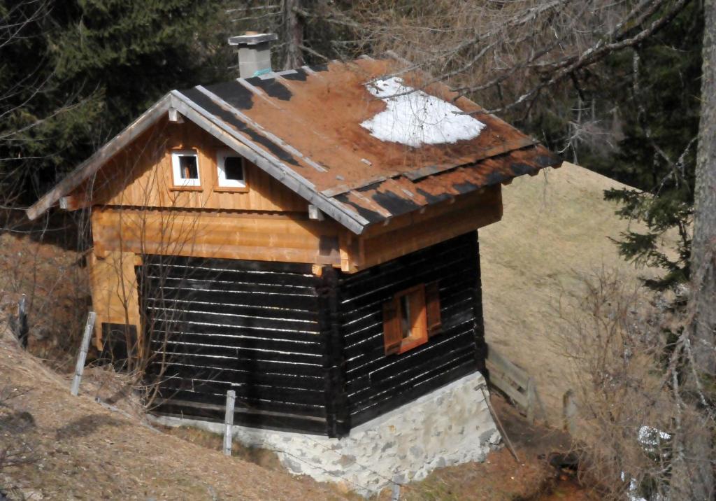 una cabaña de madera con nieve encima en Lärchenhütte en Stall