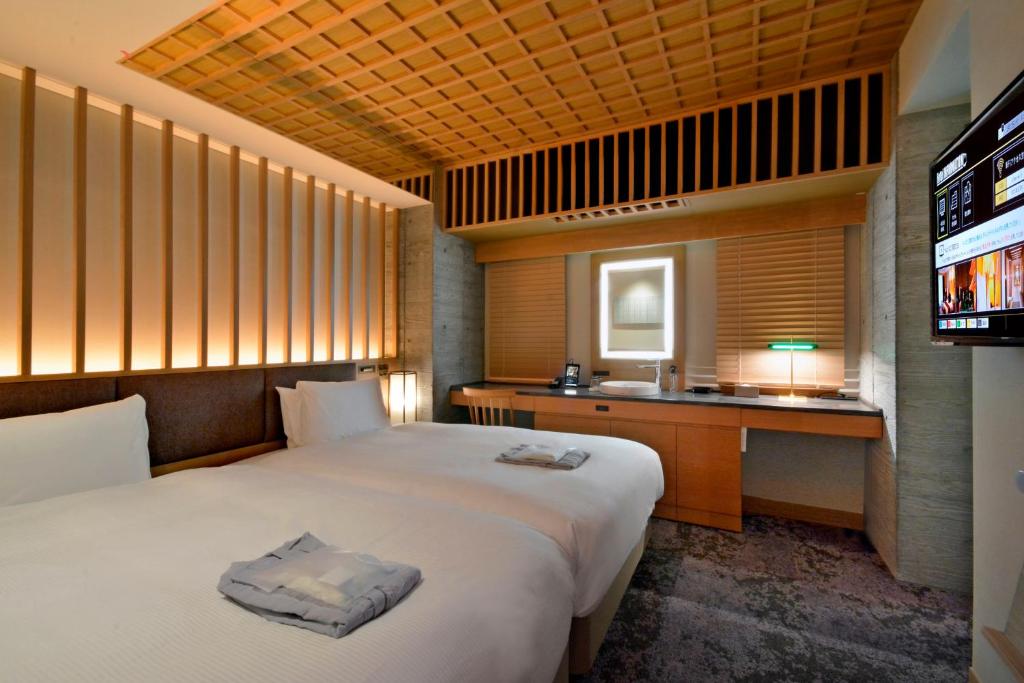 東京にあるホテルヒラリーズ赤坂のベッドとテレビが備わるホテルルームです。