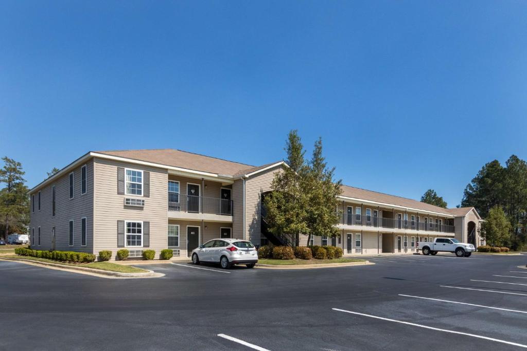 un gran edificio con coches estacionados en un estacionamiento en Studio 6-Statesboro, GA, en Statesboro