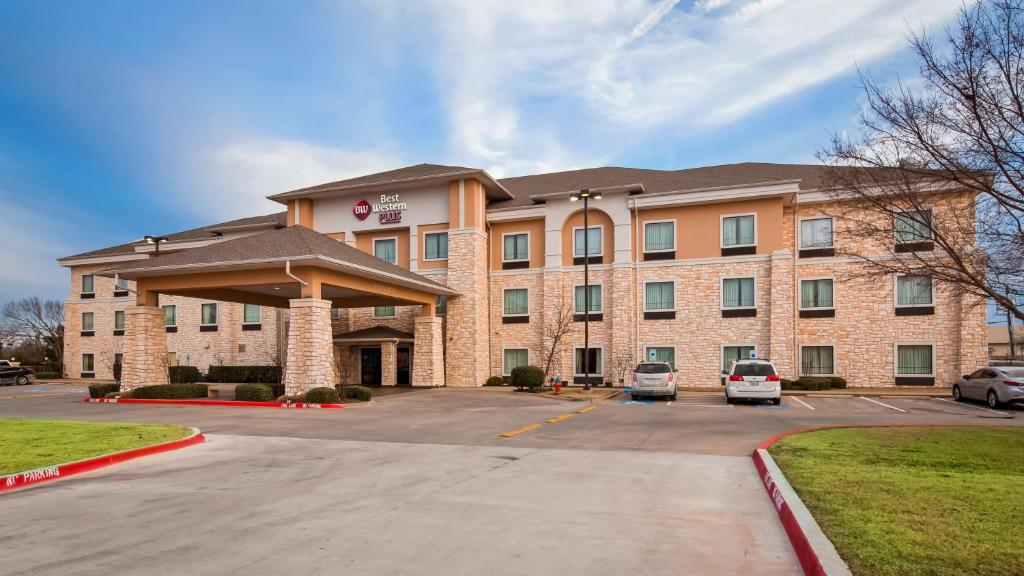 a hotel with a parking lot in front of it at BEST WESTERN PLUS Christopher Inn and Suites in Forney