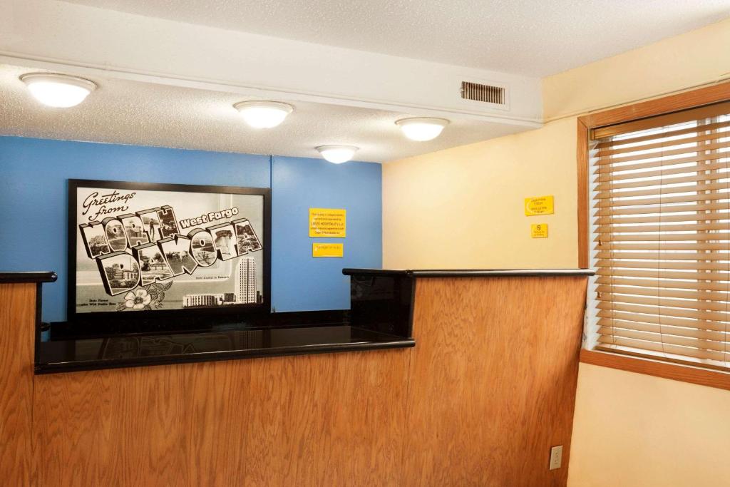 a waiting room with a flat screen tv on a wall at Super 8 by Wyndham West Fargo Main Ave ND in West Fargo