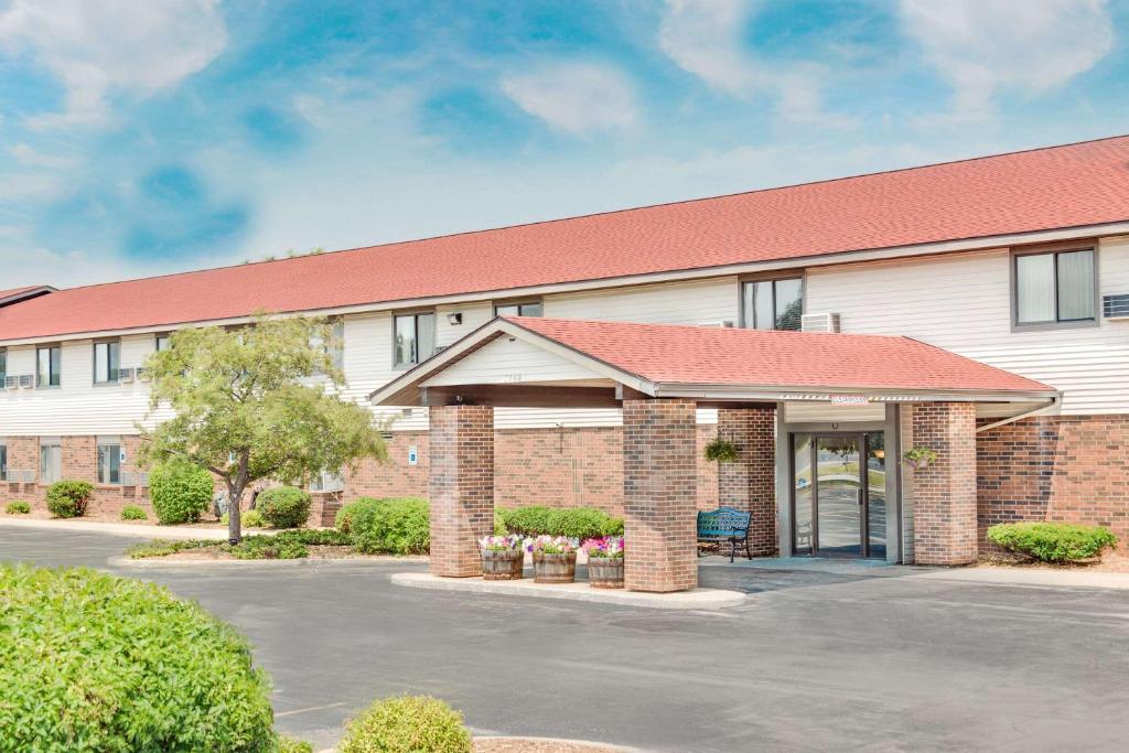 a building with a parking lot in front of it at Super 8 by Wyndham Green Bay Near Stadium in Green Bay