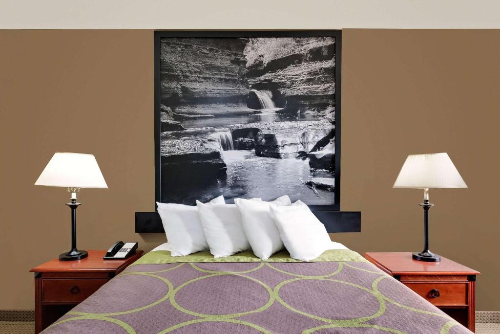 Habitación de hotel con 1 cama con 2 lámparas en Super 8 by Wyndham Ithaca, en Ithaca