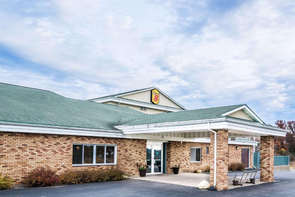 a gas station with a green roof at Super 8 by Wyndham Osseo WI in Osseo