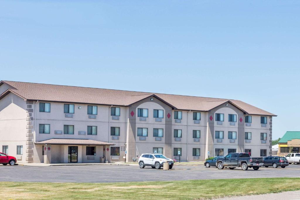 a large building with cars parked in a parking lot at Super 8 by Wyndham Sioux City South in Sioux City