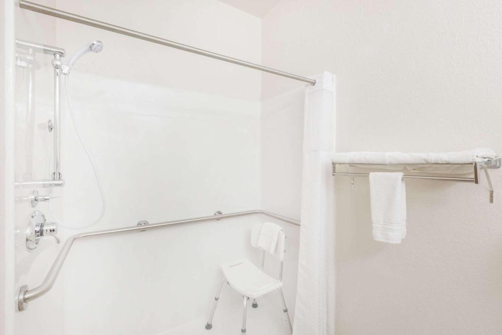 bagno bianco con doccia e servizi igienici di Super 8 by Wyndham Holton a Holton