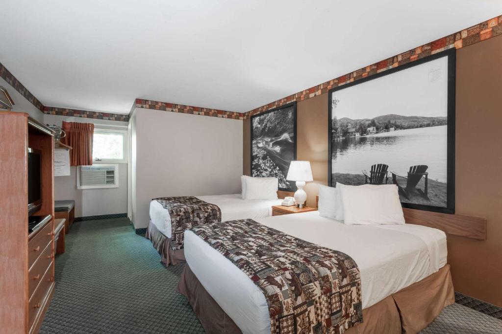 a hotel room with two beds and a large painting on the wall at Super 8 by Wyndham Lake George/Downtown in Lake George