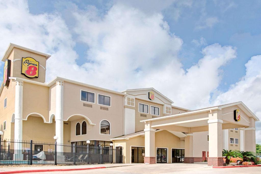 a large building with a donut sign on it at Super 8 by Wyndham Intercontinental Houston TX in Humble