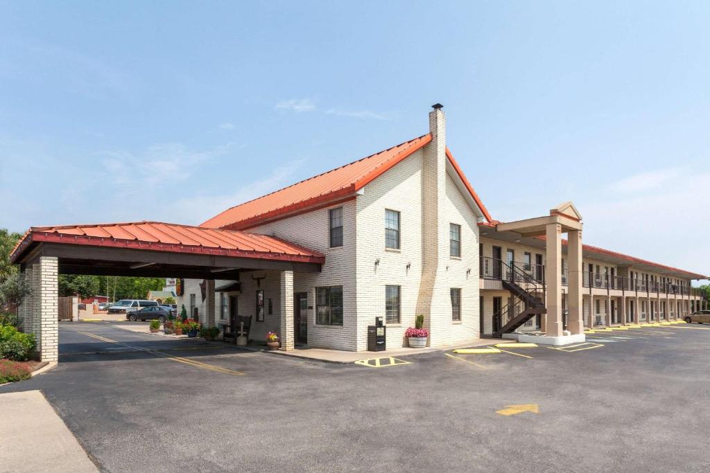 ein Hotel mit orangefarbenem Dach und einem Parkplatz in der Unterkunft Super 8 by Wyndham Fredericksburg in Fredericksburg