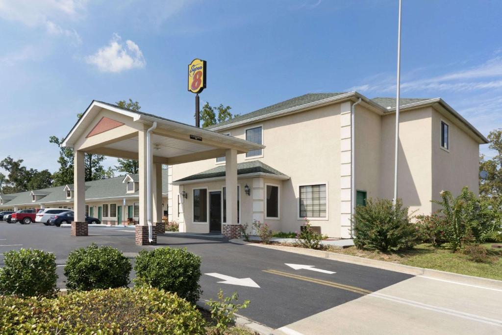 a building with a sign in a parking lot at Super 8 by Wyndham Chatsworth/Dalton in Chatsworth