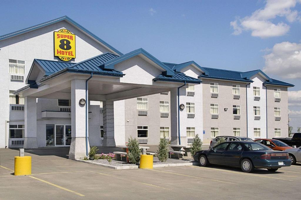 un hotel con un coche aparcado en un aparcamiento en Super 8 by Wyndham Fort Saskatchewan en Fort Saskatchewan