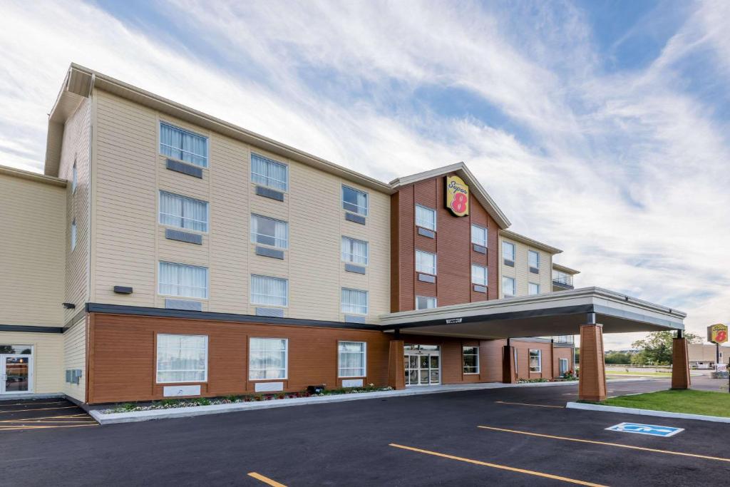 a hotel with a parking lot in front of it at Super 8 by Wyndham Mont Laurier in Mont-Laurier