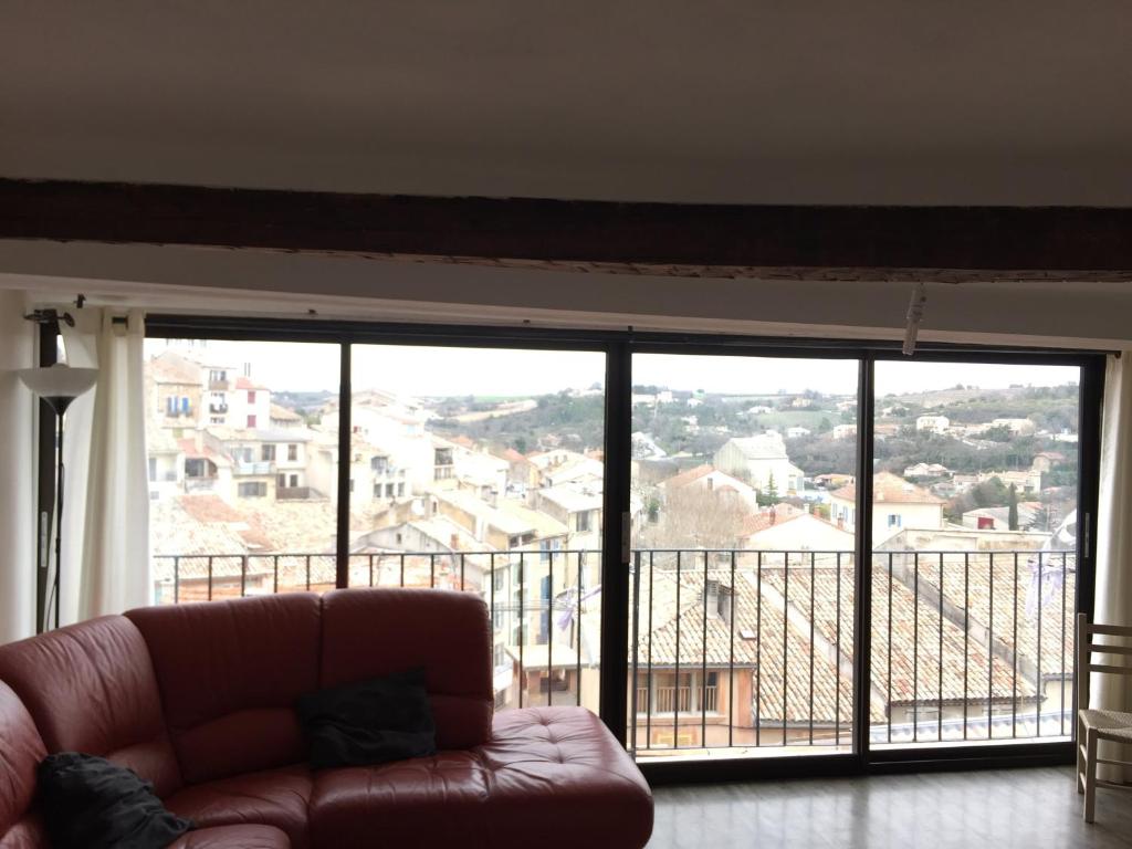 d'un salon avec un canapé en face d'une grande fenêtre. dans l'établissement Maison Village Au Coeur De La Lavande, à Valensole