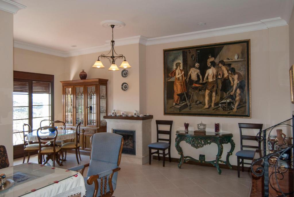 a living room with a dining table and a painting on the wall at El Palacete in Setenil
