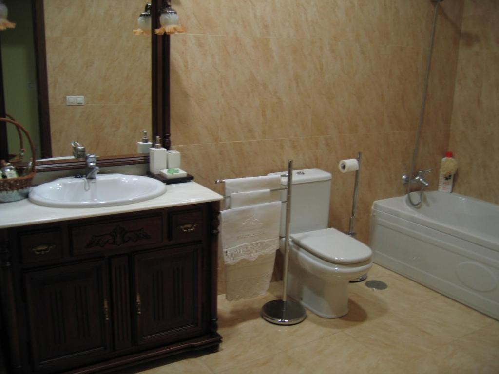 a bathroom with a sink and a toilet and a tub at El Palacete in Setenil