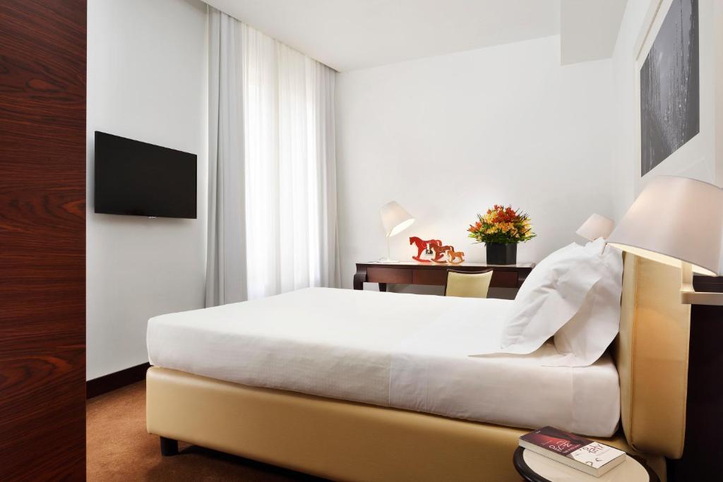 a hotel room with a bed and a television at Milano Castello Luxury Apartment in Milan