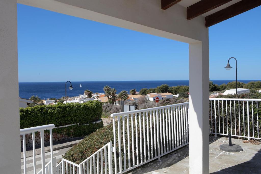 uma vista para o oceano a partir do alpendre de uma casa em Villa Binicudi em Binibeca