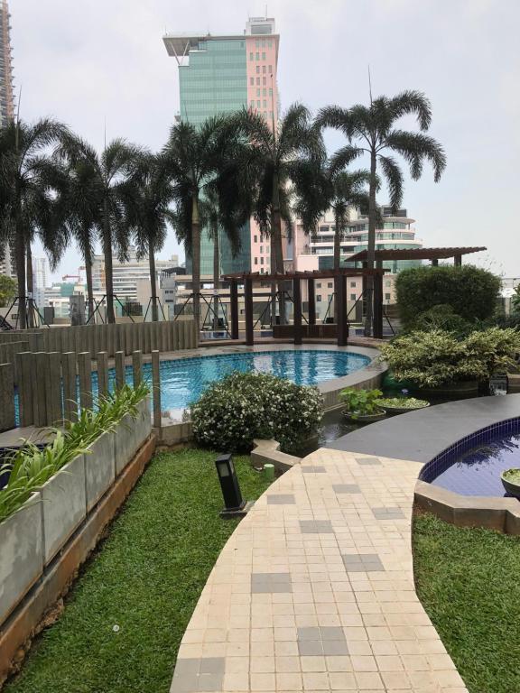 ein Pool mit Palmen und ein Gebäude in der Unterkunft Onthree20 Residencies 2 Room 3 Bed Apartment in Colombo