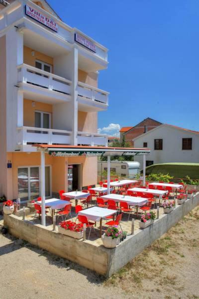 a building with tables and umbrellas in front of it at Villa D&I in Srima