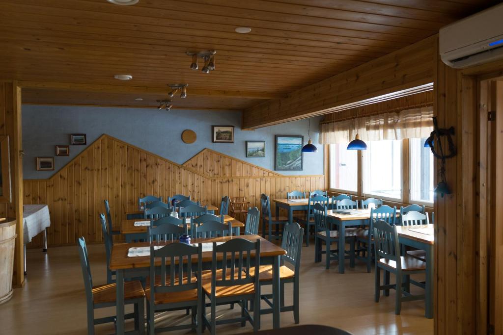 a dining room with tables and chairs in a restaurant at Paimentupa in Kolinkylä