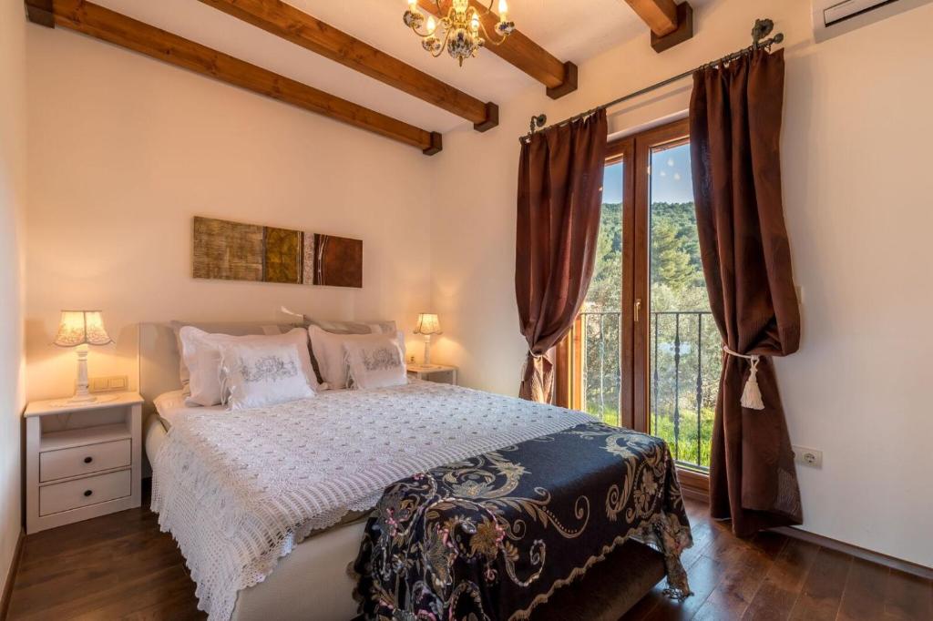a bedroom with a bed and a large window at Apartments Villa San Antonio in Slatine