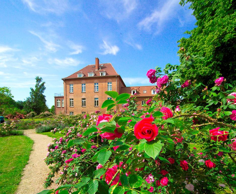 a building with a bunch of flowers in front of it at Gutshaus Gottin in Warnkenhagen