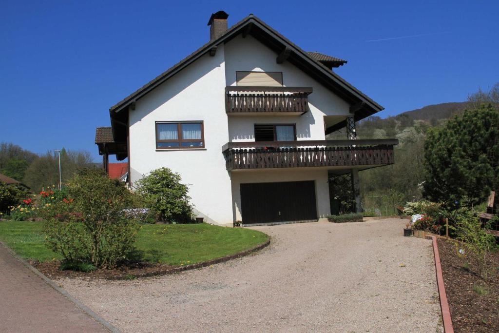 een wit huis met een balkon en een oprit bij Ferienwohnung Schlierbachtal in Lindenfels