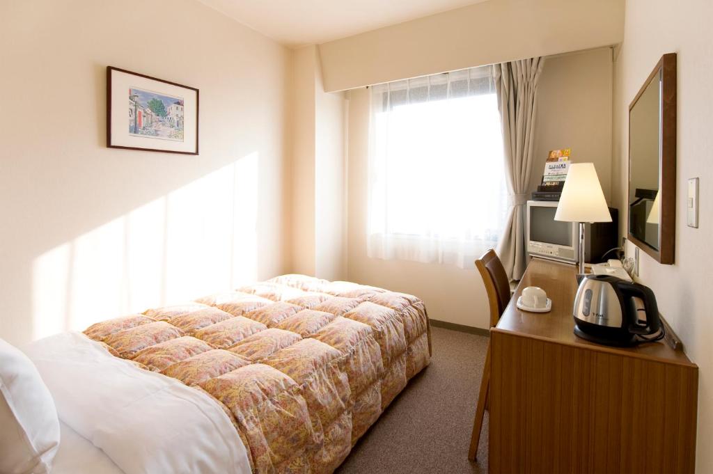 Postel nebo postele na pokoji v ubytování Hotel Keifuku Fukui Ekimae